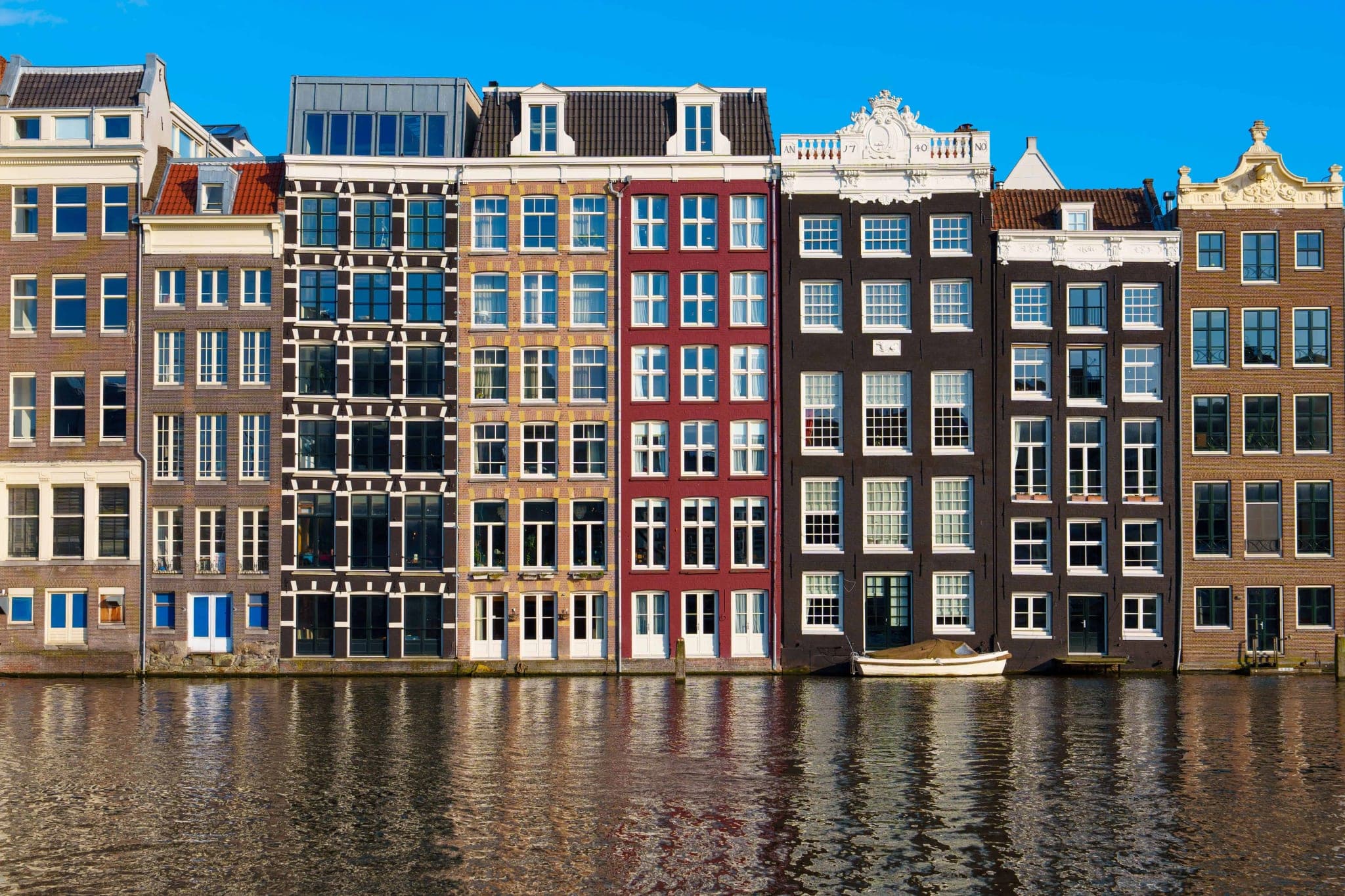 Fotobehang Amsterdamse Grachtenpanden met Zonnig Water