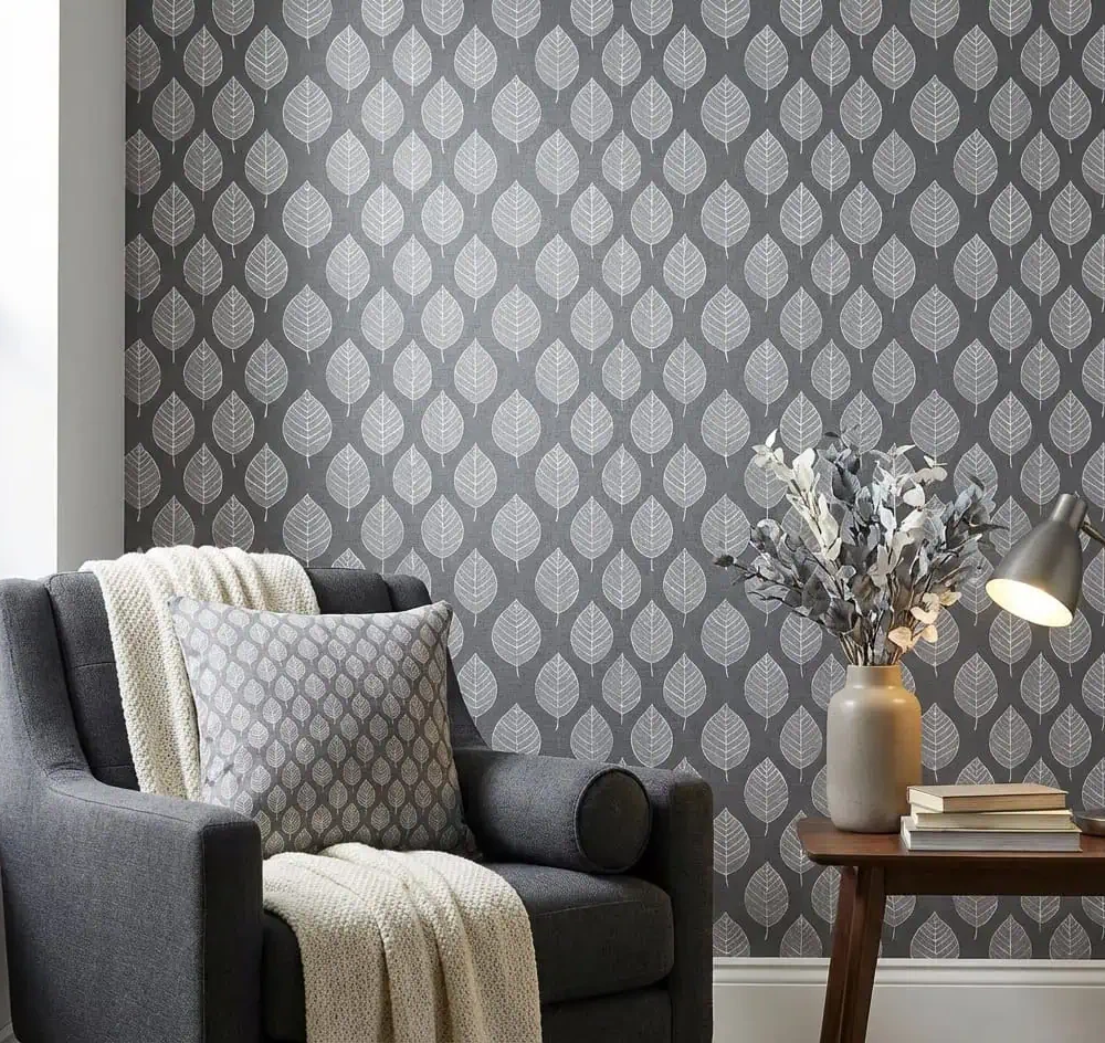 bladeren behang grijs achter fauteuil en bijzettafel in woonkamer