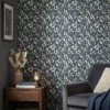 botanisch behang blauwgrijs achter fauteuil en bijzettafel in woonkamer