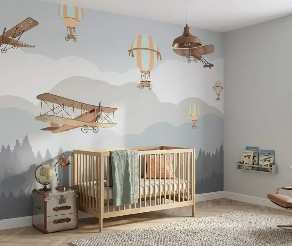 kinderkamer behang vliegtuigen grijs achter ledikant en vintage koffer in kinderkamer