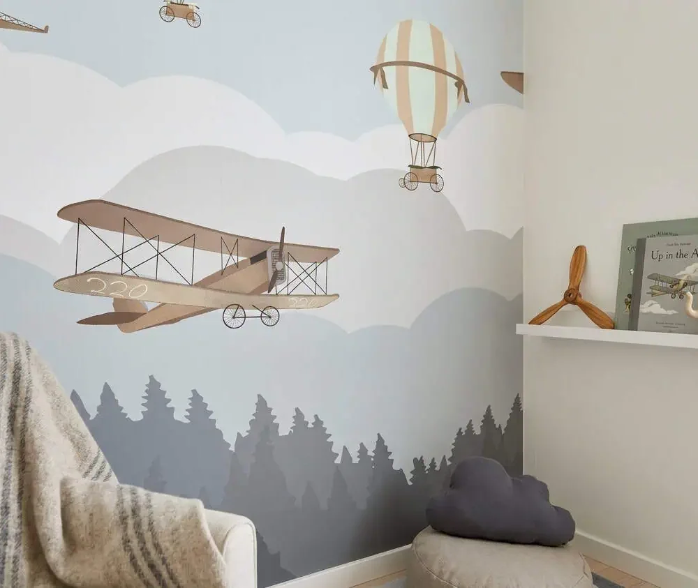 kinderkamer behang vliegtuigen grijs achter fauteuil en wandplank in kinderkamer